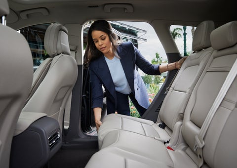 A woman slides the second-row seat forward to create more cargo space | Loveland Lincoln in Loveland CO