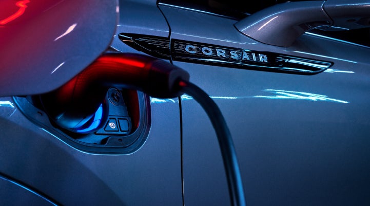 A charger plugged into the charging port of a 2024 Lincoln Corsair® Plug-in Hybrid model. | Loveland Lincoln in Loveland CO
