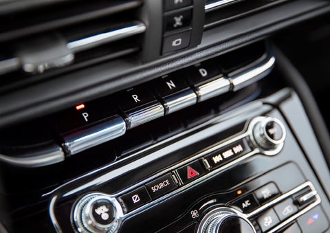 The Park button on the elegant Piano Key Shifter is lit up and engaged as light dances off the chrome accents and horizontal design lines | Loveland Lincoln in Loveland CO