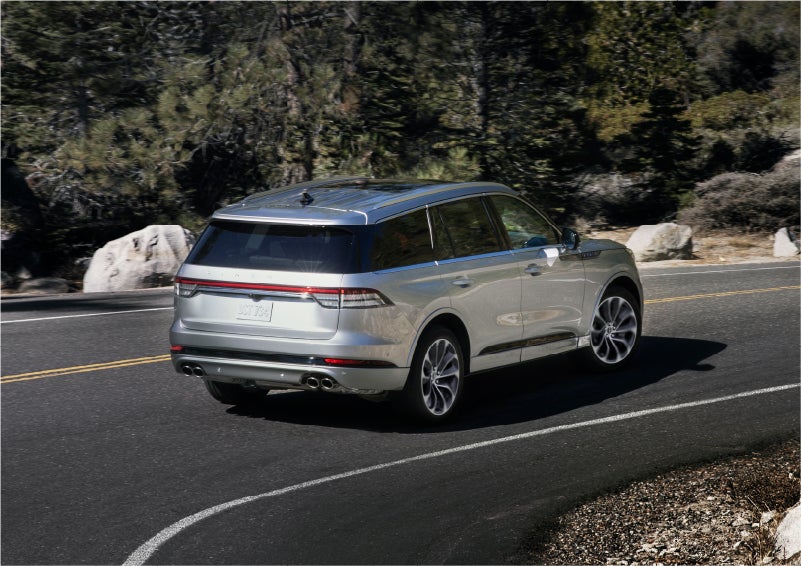 A 2023 Lincoln Aviator® Grand Touring model is shown being driven on a tight turn of a mountain road | Loveland Lincoln in Loveland CO
