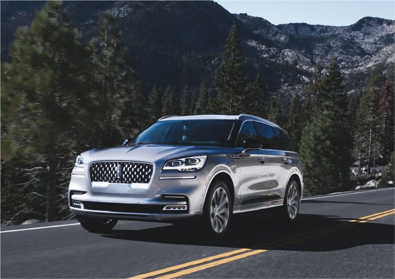 A 2023 Lincoln Aviator® Grand Touring SUV being driven on a winding road to demonstrate the capabilities of all-wheel drive | Loveland Lincoln in Loveland CO