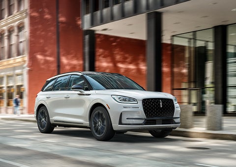 The 2024 Lincoln Corsair® SUV with the Jet Appearance Package and a Pristine White exterior is parked on a city street. | Loveland Lincoln in Loveland CO