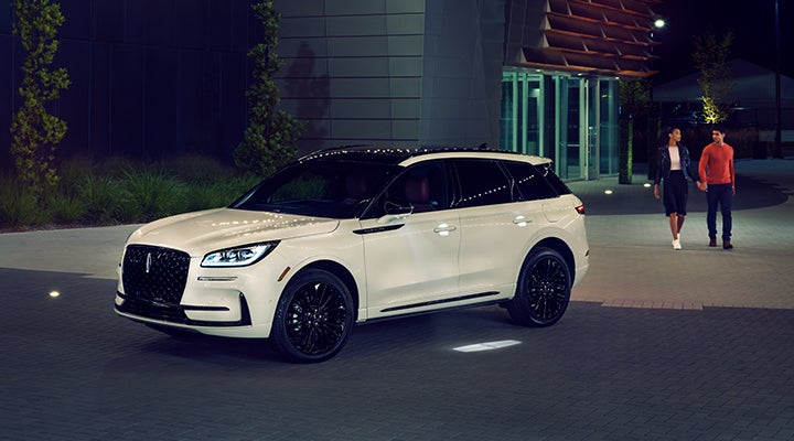 Two people approach a 2024 Lincoln Corsair® SUV featuring the available Jet Appearance Package. | Loveland Lincoln in Loveland CO