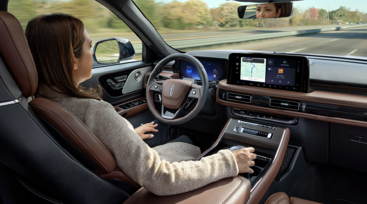 A woman is seen sitting in the driver’s seat of her 2025 Lincoln Aviator® SUV with her hands off the steering wheel. | Loveland Lincoln in Loveland CO