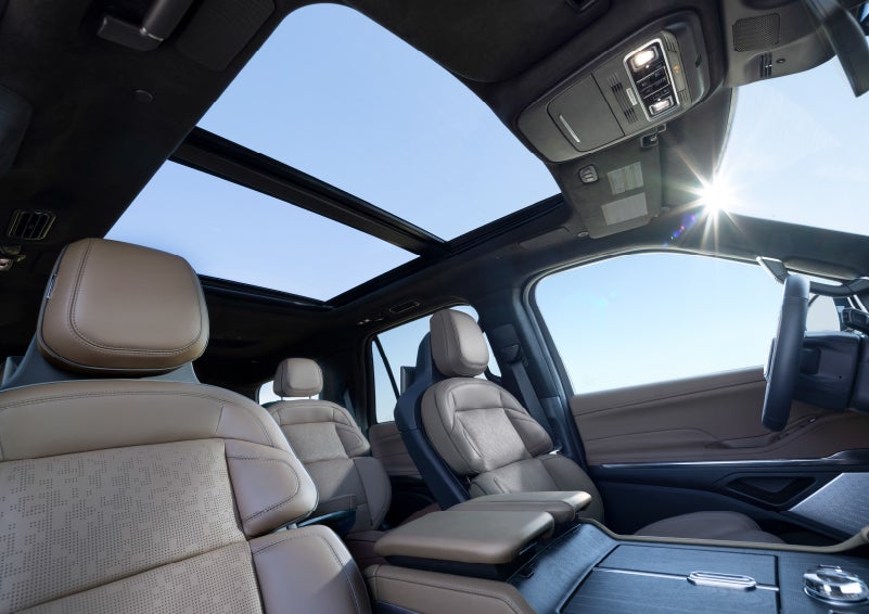 A hand is about to turn the Lincoln Drive Modes knob on the center console.