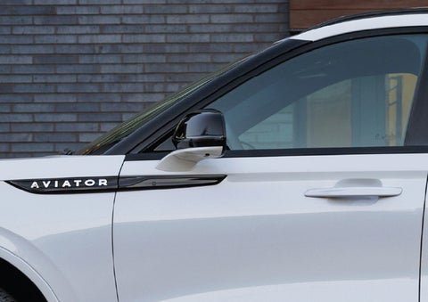 The driver’s side door and fender badging of a white 2026 Lincoln Aviator® SUV are showcased. | Loveland Lincoln in Loveland CO