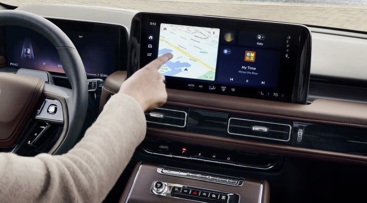 A person is tapping the center display touchscreen of a 2026 Lincoln Aviator® SUV. | Loveland Lincoln in Loveland CO