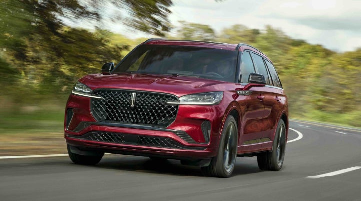 A 2027 Lincoln Aviator® SUV is being driven on a country road | Loveland Lincoln in Loveland CO