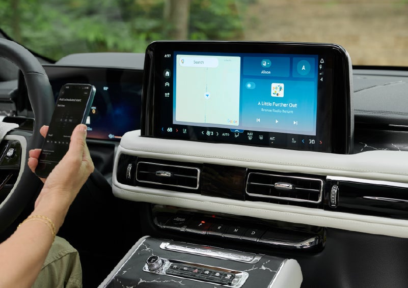 A person pairs thier phone with the center touchscreen of a 2027 Lincoln Aviator® Black Label™ SUV | Loveland Lincoln in Loveland CO
